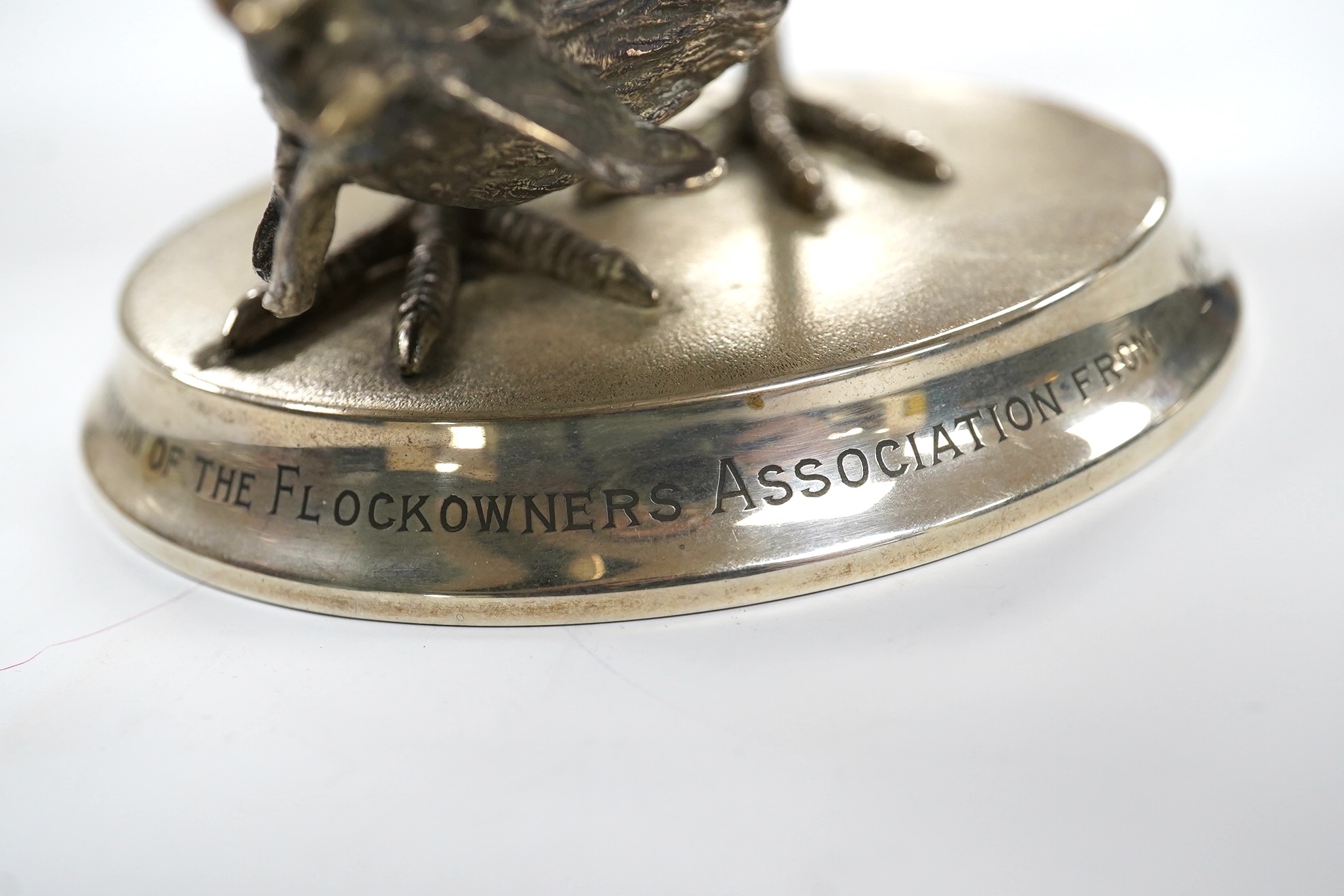 An Elizabeth II silver presentation cockerel, on a circular base with engraved inscription, by Garrard & Co Ltd, London, 1953, overall height 14cm, weighted. Condition - fair to good